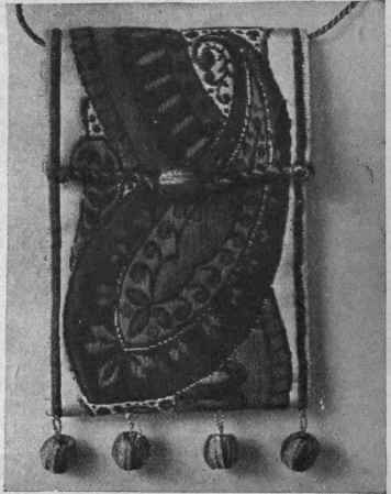 A novel bridge purse made of fancy galon, decorated with small gold balls and provided with a long neck cord