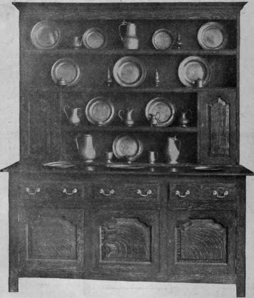 A typical example of an old Yorkshire dresser, with cupboards for cruets at the sides of the shelves. Such a dresser forms a good background for old pewter or silver