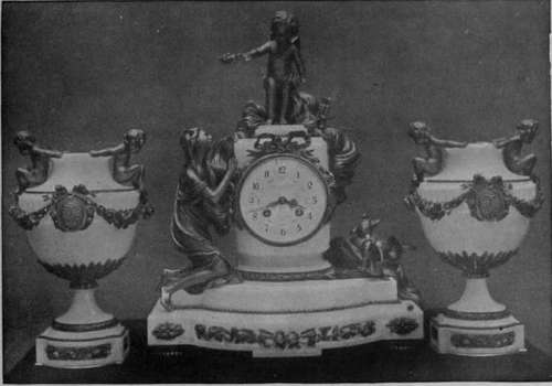 Clock and vases in statuary marble with applied designs and figures in mercury gilt