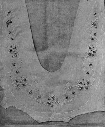 Detail of embroidered suede collar. Dull beads arranged in groups of three and four, connected by strands of heavy filoselle stitched down with fine