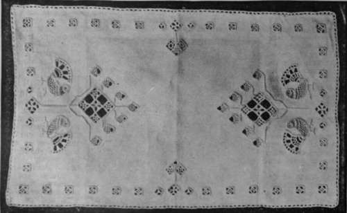 Tray cloth in cut work embroidery. The stiff conventional tree with acorns at either end forms a characteristic design, while the quaint birds give scope for fine open buttonholing with good effect