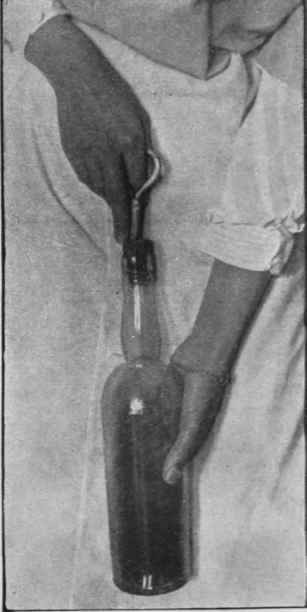 When drawing a cork one finger should be placed on it. as seen above. If this is done, the corkscrew will not drag through the cork