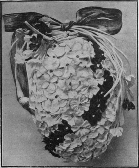 A dainty decoration for an Easter egg, a background of lilac petals, crossed by a diagonal band of dark blue forget me nots. Such eggs are charming as table ornaments