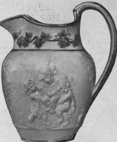 A milk jug in porcelain, moulded in low relief, partly painted in colours and gilded. The classical subject is frankly imitated from