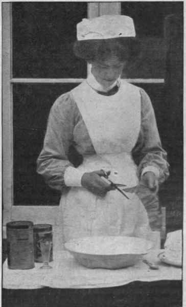 Making an ice poultice. The block of ice on a plate, a basin, a little chloroform, a tin of salt, and a tin of linseed meal should all be placed ready. The nurse is cutting the gutta percha tissue to the required size