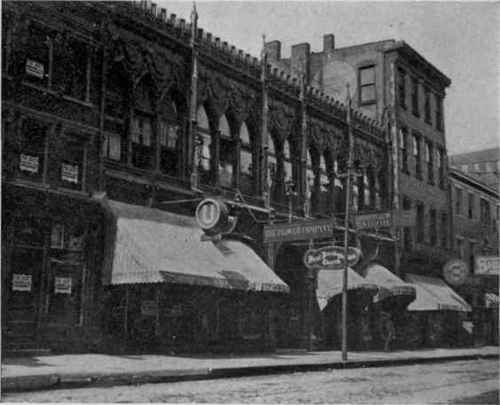 First Presbyterian Church located back from street. With growth of retail business on Fourth Street the space in front was built in with stores and offices. Entrance to church through building shown by sign. Cincinnati.